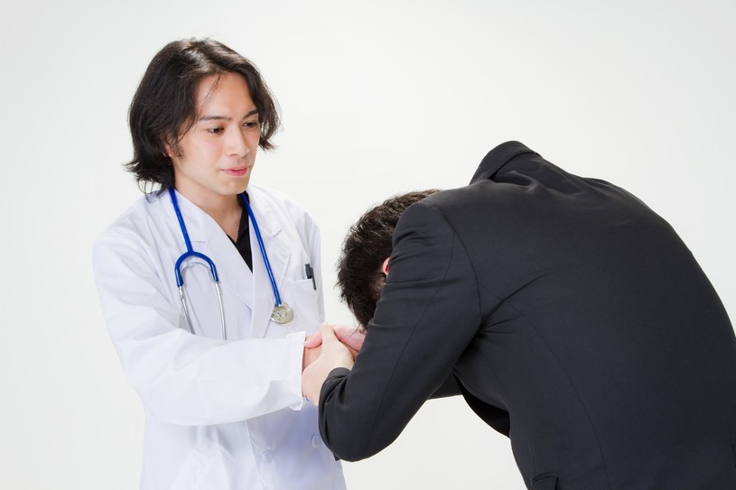 医者に握手を求める男性